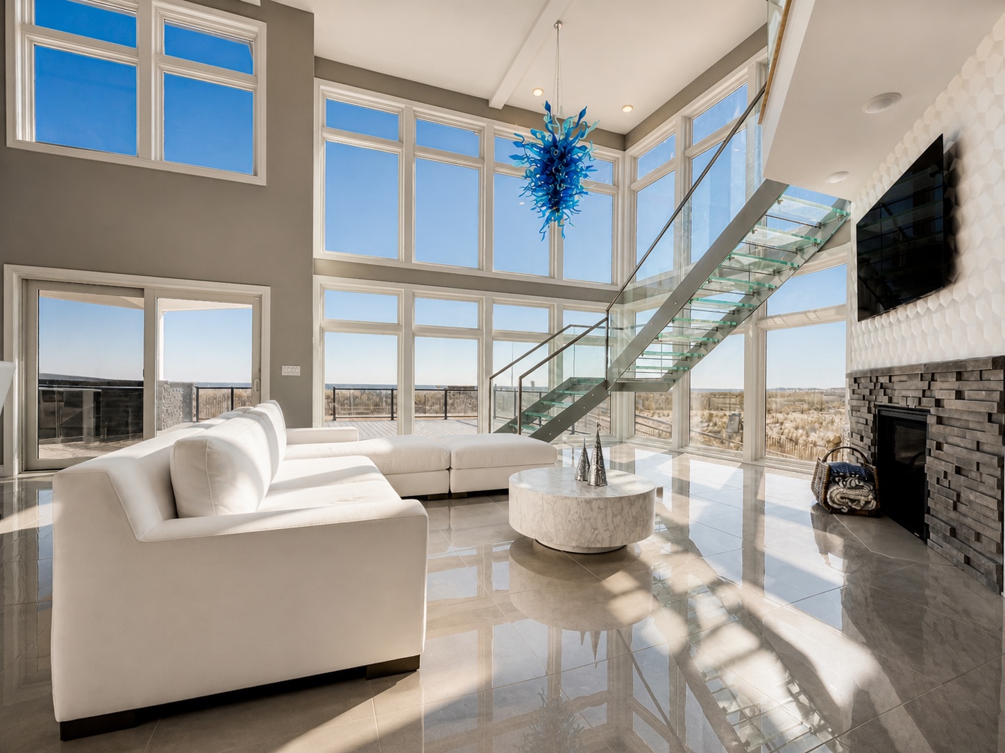Modern oceanfront living room with glass staircase and Chihuly chandelier — Mantoloking NJ
